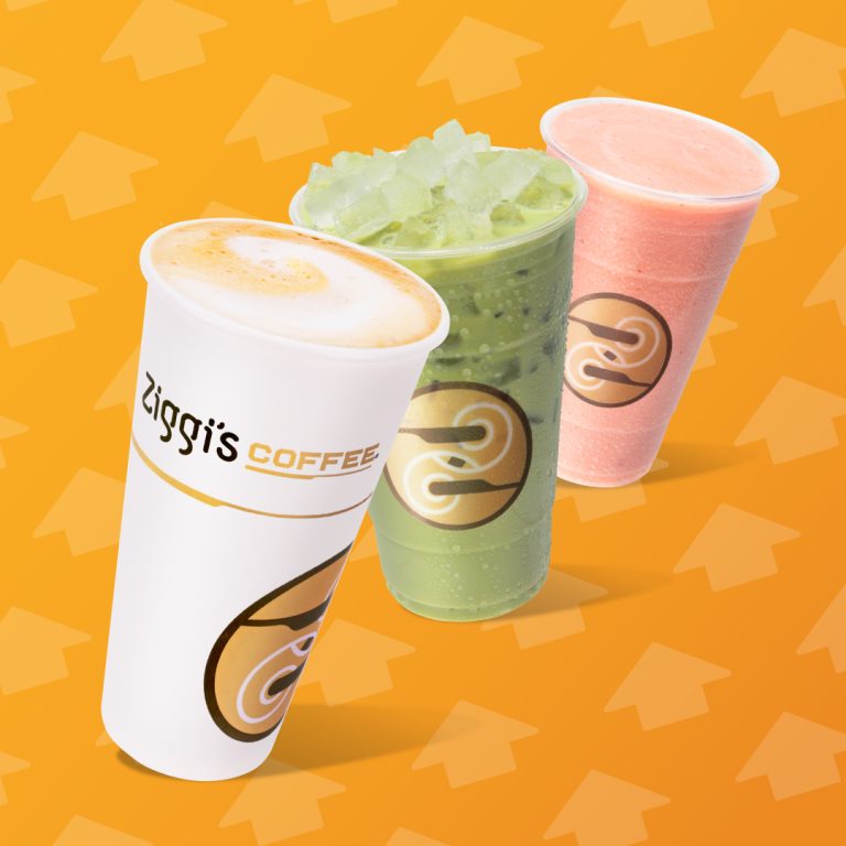 Three Ziggi's Coffee drinks displayed against a bright orange background with upward arrow patterns: a hot latte in a branded white paper cup (foreground), an iced matcha green tea drink with crushed ice in a clear cup (center), and a pink strawberry smoothie in a clear cup (back right).